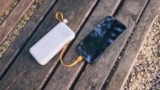 A power bank currently charging a smartphone via cable