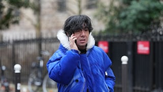 A man in a blue jacket is on the phone.