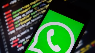 Smartphone with WhatsApp Logo in Front of IT Code