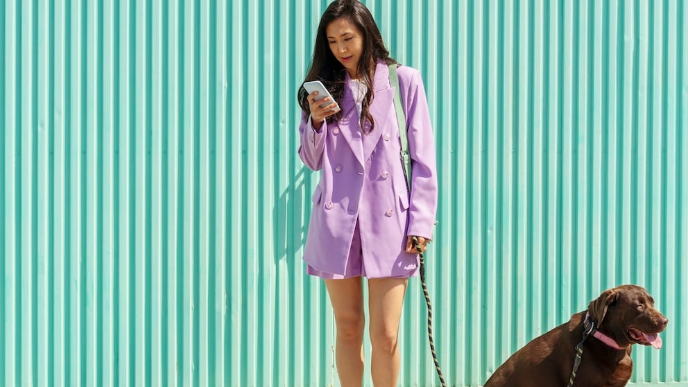 Woman with Dog Looks at Smartphone
