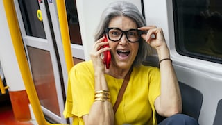Woman Talks on the Phone in the Train While Touching Her Glasses