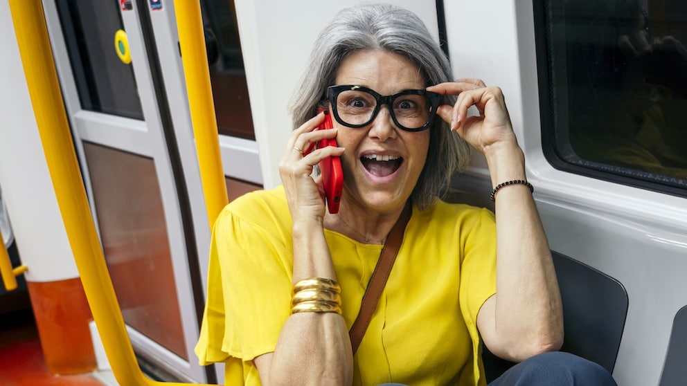 Woman Talks on the Phone in the Train While Touching Her Glasses