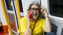 Woman Talks on the Phone in the Train While Touching Her Glasses