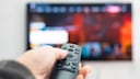 Person Points Remote at TV