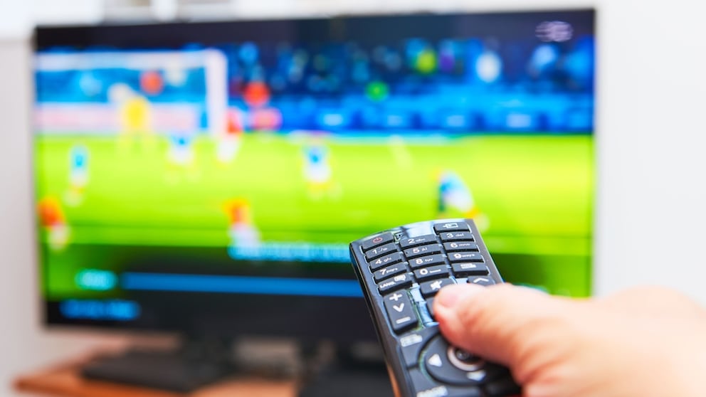 Person points a remote at a TV