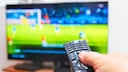 Person points a remote at a TV