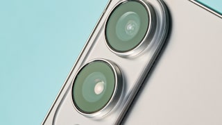 Close-up of the back of a silver smartphone featuring two large, vertically aligned camera lenses against a light blue background
