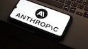 Anthropic logo is visible on a smartphone