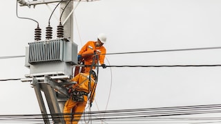 Workers repair a power pole