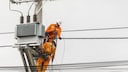Workers repair a power pole