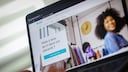 A laptop displaying the Vinted website. On the French-language homepage, the Vinted logo, a wardrobe filled with clothes, and a person in the background are visible. In the foreground, there's a field with the text "Prêts à faire du tri dans vos placards?" and a turquoise button.