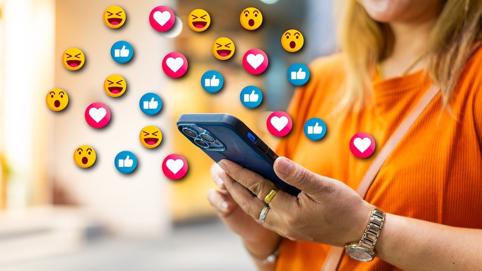 A woman uses her smartphone, with various emojis symbolically appearing above it.