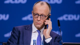 Chancellor Friedrich Merz talks on his smartphone