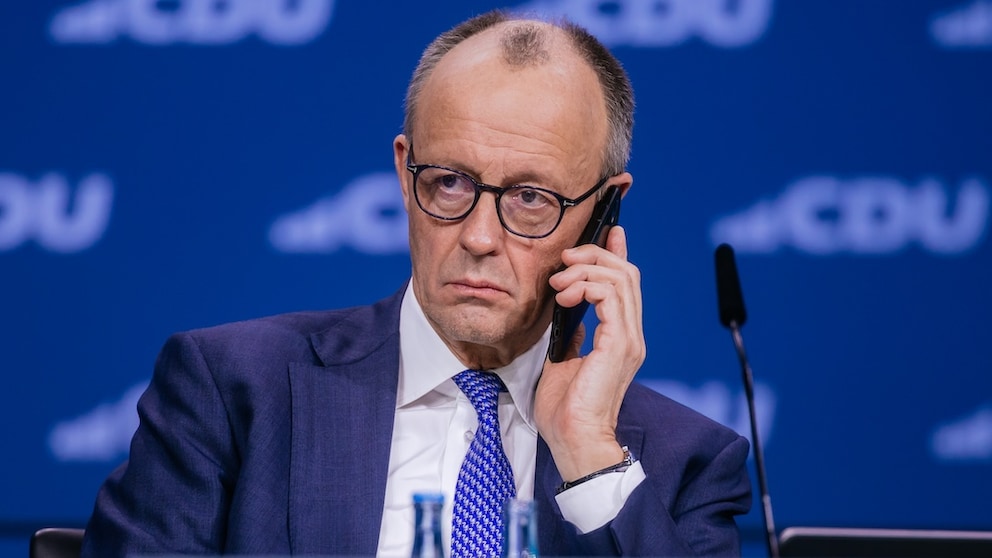 Chancellor Friedrich Merz talks on his smartphone