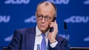 Chancellor Friedrich Merz talks on his smartphone