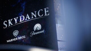 Large display board with the inscription "Skydance" and the logos of Warner Bros. and Paramount against a dark background.
