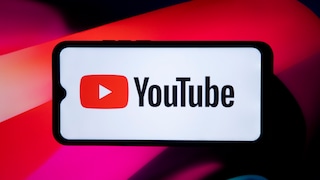 Smartphone with a large YouTube logo on the display against an abstract red-pink background