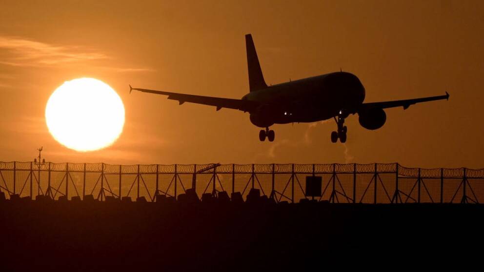 Airplane flies at sunset