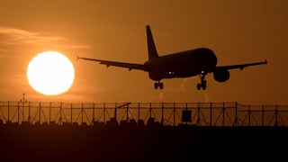 Airplane flies at sunset