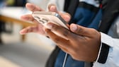 A man holds an iPhone 16 in his hands