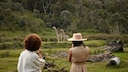 Two women photograph giraffes