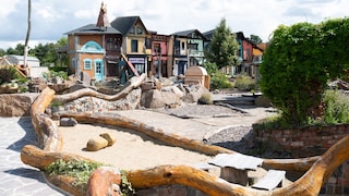 At the marketplace of the "ArkaZien" amusement park, various shops are housed in colorful little buildings.