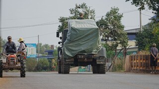 Cambodian Military Vehicle Passes Tractor of Evacuees