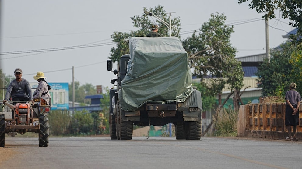 Cambodian Military Vehicle Passes Tractor of Evacuees