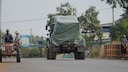 Cambodian Military Vehicle Passes Tractor of Evacuees