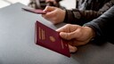 Two people present their passports at the airport