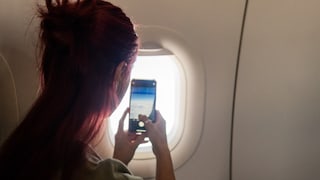 Woman Filming on Airplane
